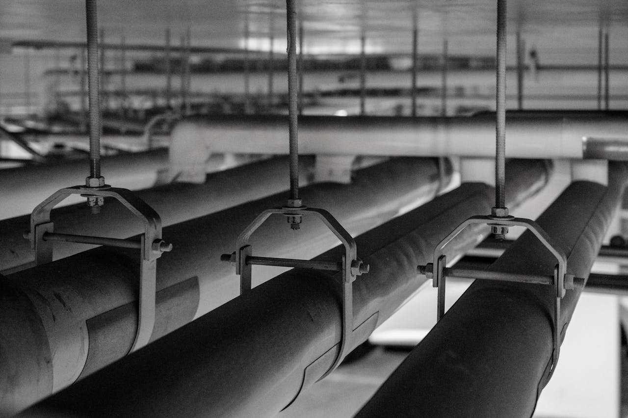 Black and white photo of industrial pipes and fittings, captured in a production facility.